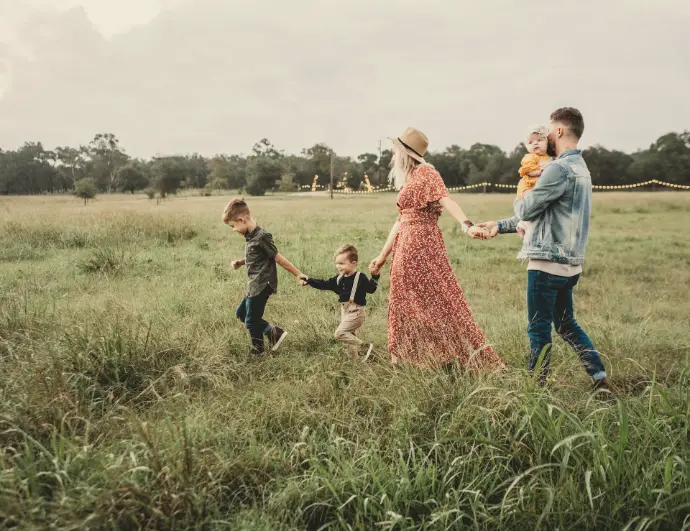 woman holding man and toddler hands during daytime